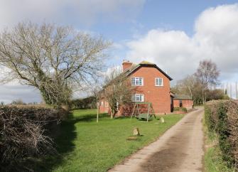 A drive leads to a brick-built Herefordshire country cottage.