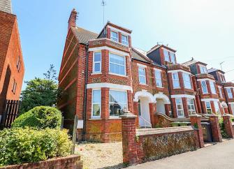 End of terrace exterior with off-road parking of a seaside holiday home in Hunstanton.