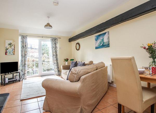 A lounge with French windows, sofas, coffee table and a TV.