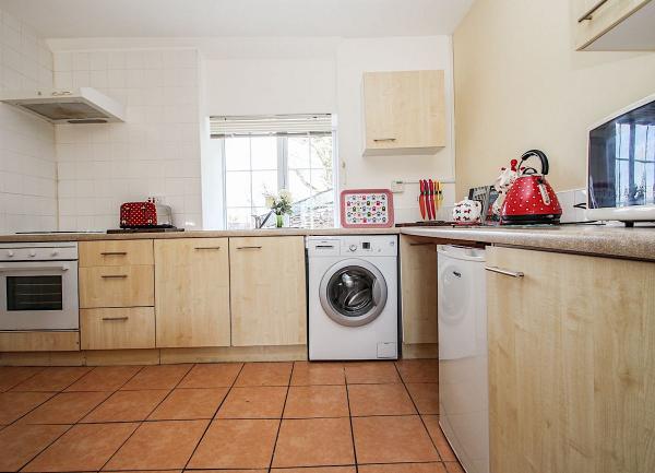 A fitted kitchen with oven, washing machine, dishwashing and smaller appliances.