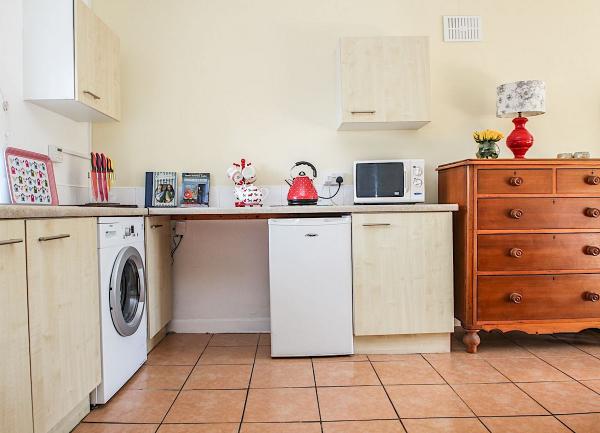 Kitchen corner with worktops, washing machine and an antique chest-of-drawers