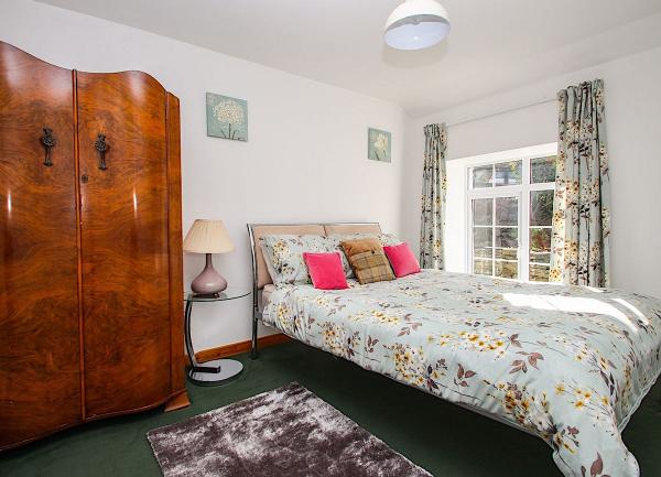 A double bedroom with a bed and antique walnut-veneered wardrobe.