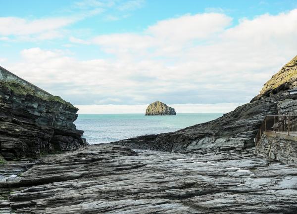 A flat bed of granite rock leading to the shore with an off-shore island in the distance.