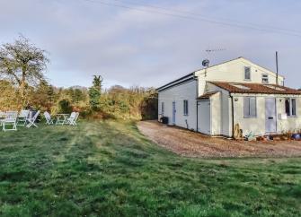 A chalet bungalow for self-catering holidays in Norfolk is surrounded by open fields.