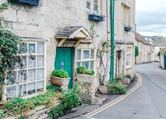 Exterior of a terraced Cotswold holiday cottage overlooking a village street.