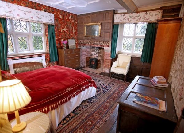 Dual aspect double bedroom with wardrobe, chests of drawers and an armchair.