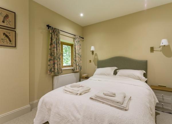 A double bedroom with bedside cabinets and wall lights.