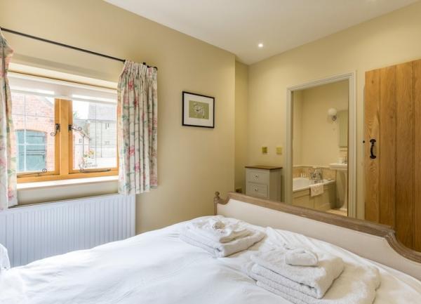 double bedroom with towel sets on the bed and an ensuite bathroom.
