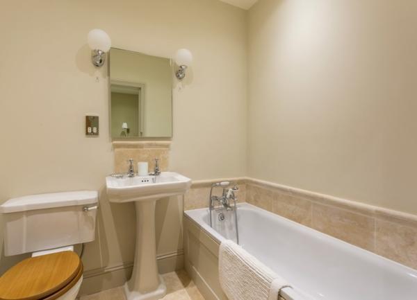 Bathroom with a bath, washbasin, WC and large wall mirror.
