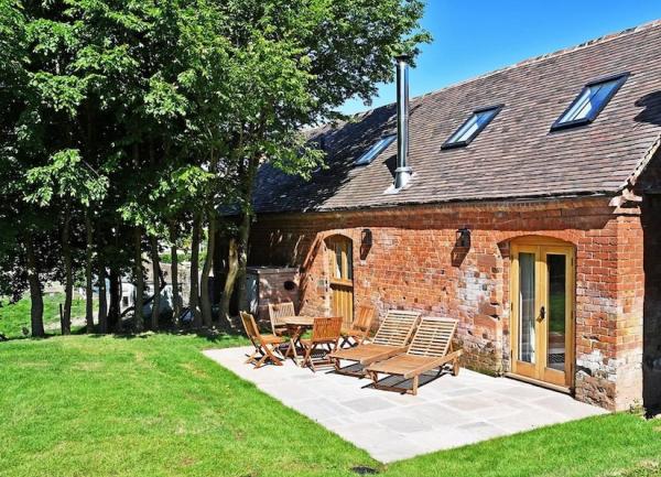 A garden patio with outdoor dining furniture and twin sun loungers.
