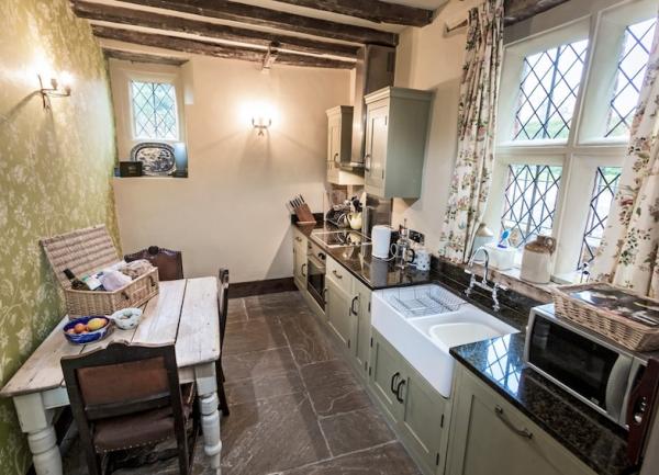 A fitted kitchen with a breakfast table with oven, microwave and other worktop appliances.