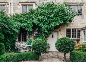 A Cotswold holidy cottage with a vine-covered exterior.