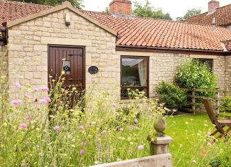 Single storey of a barn conversion overlooking a lawn on a North Yorkshire farm.