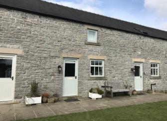 Exterior of stone-built, barn conversion in the Peak District.