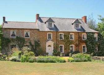 A large old Northamptonshire rectory looks out over flowerbeds and a spacious lawn.