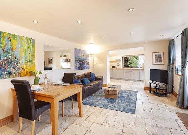 The lounge in a Porlock Weir holiday cottage has a flagstone floor, sofas and TV.