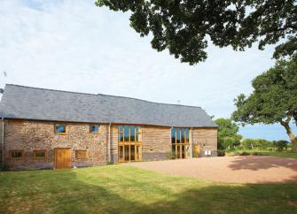 Bromyard barn conversion with large floor-height windows, in open countryside.