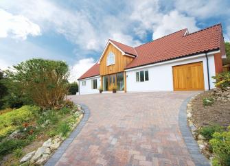 Large modern chalet bungalow approached by a spacious block paved drive.