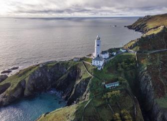 A lighthouse on a clifftop overlooking the ocean.