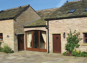 Exterior of a single-storey, stone-built, Cheshire holiday cottage.