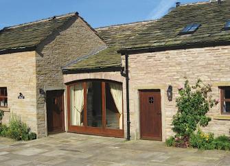 Exterior of a single-storey, stone-built, Cheshire holiday cottage.