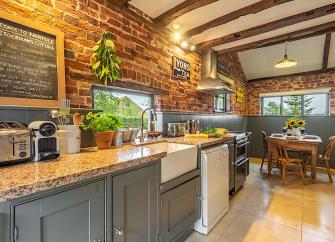 Kitchen worktops and dining table in a Norfolk cottage with oak-beamed ceilings.