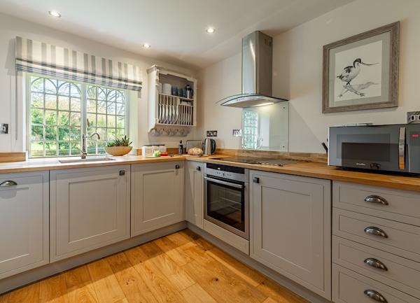 Pine floored kitchen with modern worktops and appliances.