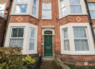 Exterior of a 3-storey Victorian seaside town house with bay windows. n