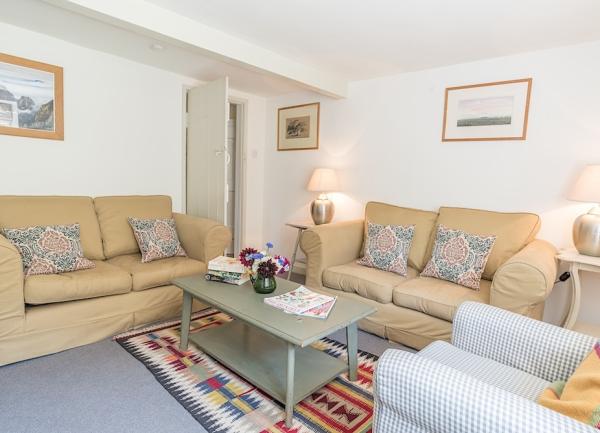 A Dorset cottage lounge with twin sofas, armchair, coffee table and table lights.