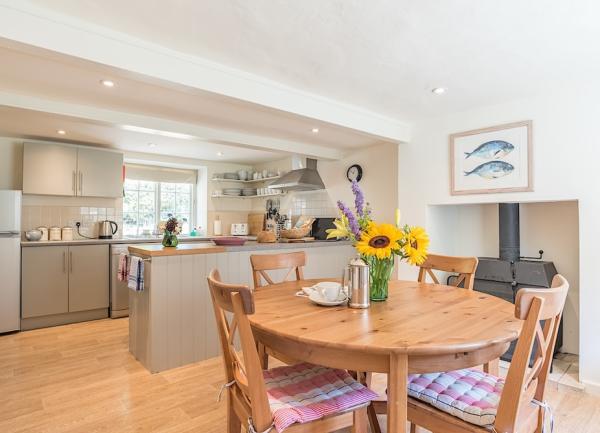 A country cottage kitchen-diner with fitted unit, full-height fridge freezer and dining table seating 4.