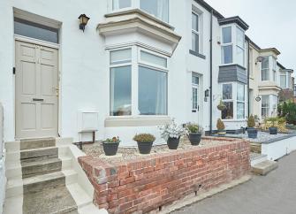 A nicely refurbished two-storey, terraced town house with a small front garden.