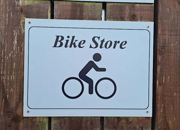 An external wooden door bearing a sign that says 'Bike Store'.