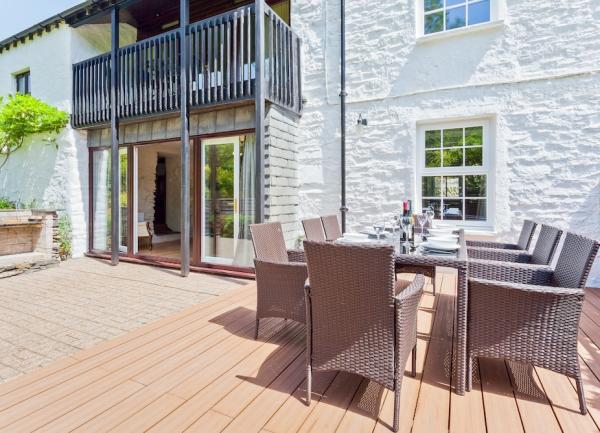 Rear exterior of The Mill with verandah and outdoor dining furniture.