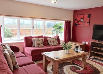 A farmhouse lounge with large sofas and a widescreen TV