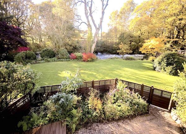 A riverside garden with a large lawn.