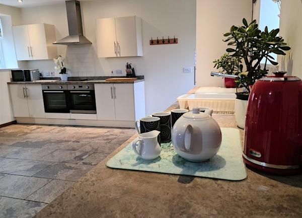 A odern Shropshire cottage kitchen with a twin oven and flagstone floors.