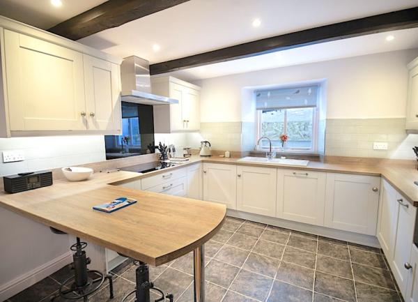 Modern fitted kitchen with breakfast bar and appliances.