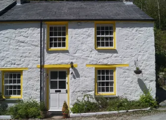 Semi-detached, stone-built, slate-roofed Cornish Cottage with wooden sash windows.