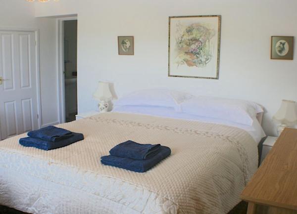 Double bedroom with bedside lights, dressing table and arm chair.