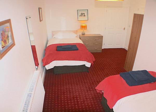 Twib bedroom with bedside chests-of-drawers and lights.