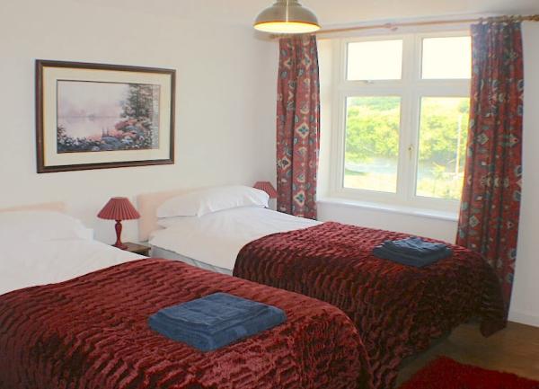 Twin bedroom with beds and towel sets.