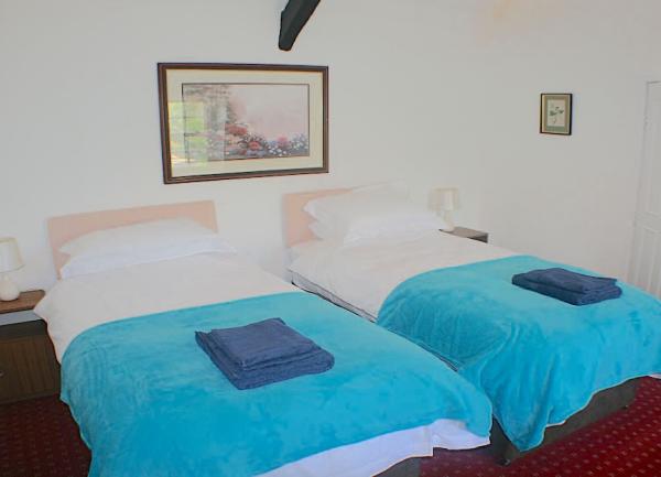 Oak beamed twi bedroom with towel sets on the beds.