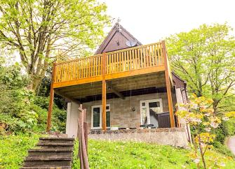A wood and stone eco lodge with a massive 1st floor balcony enjoys rural views.