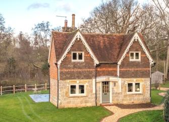 Twin-gabled extertior of a Kent farmhouse surrounded by a large, fenced lawn