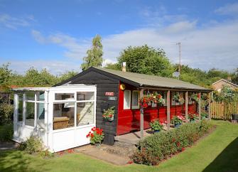 Eterior of a vintage railway carriage converted to a holiday rental in a garden.