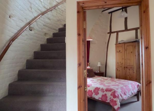 A curving staircase alongside a door to a double bedroom.
