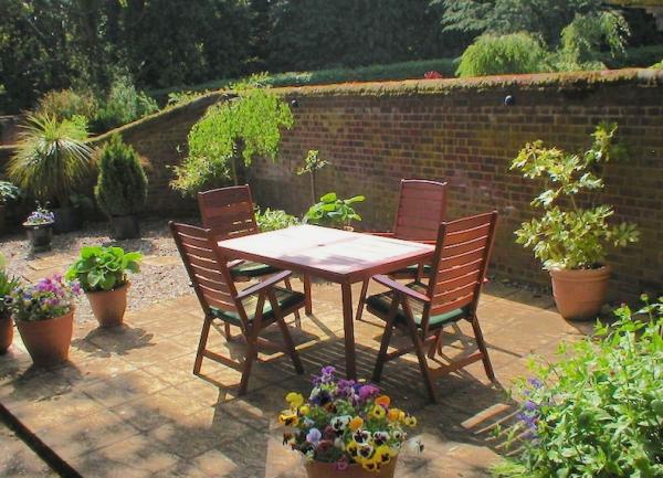 A terraced garden patio with outdoor table and chairs.