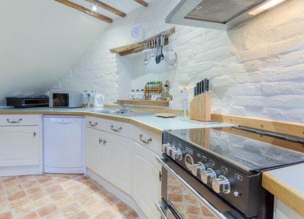 A circular kitchen with large range cooker and dishwasher.