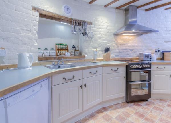 A curved row of kitchen units with an oven sink and dishwasher.