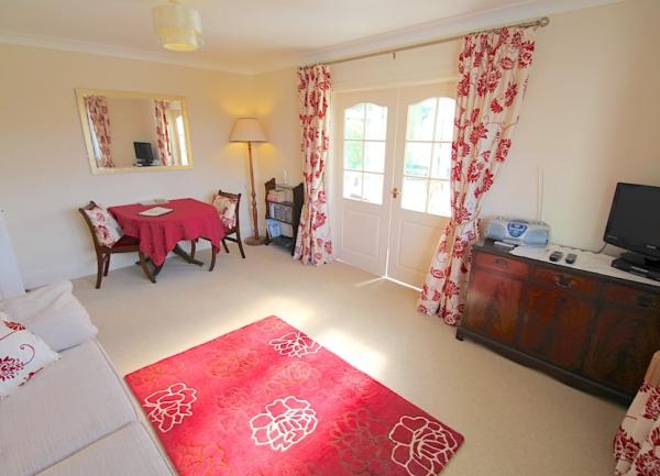A clean and tidy fitted kitchen with a mid-height oven, dishwasher and breakfast table.